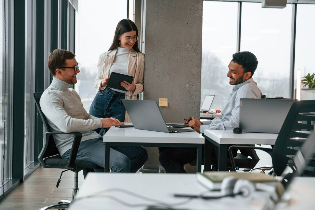 smiling and talking. men and woman are working in the office together